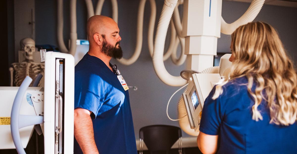 Two medical imaging students practice using an x-ray machine to create digital images.