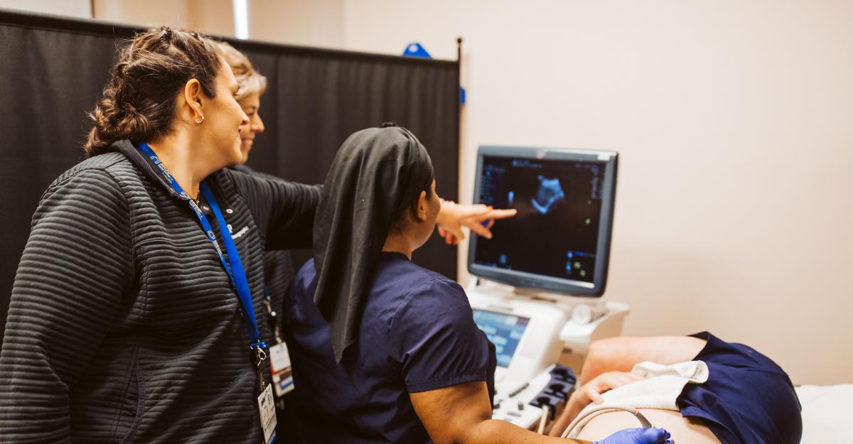 Diagnostic Medical Sonography faculty assist a MCHP student in identifying images on a monitor.
