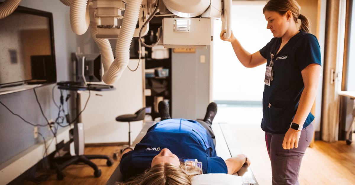 Two medical imaging students practice using an overhead x-ray system to take digital images.